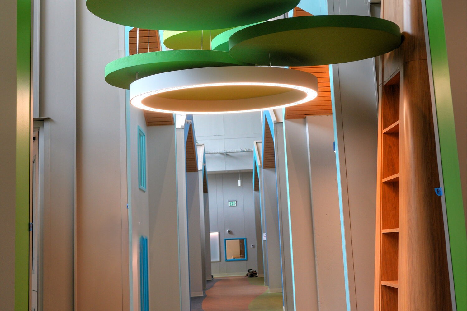 Modern hallway design with vibrant hanging lights and wood accents.