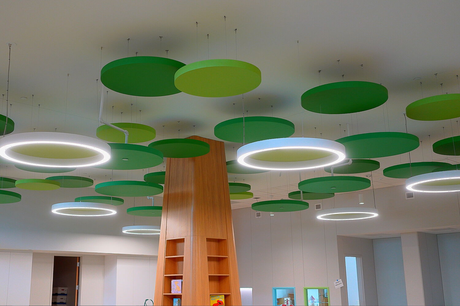 Colorful ceiling design with floating green circles and modern lighting fixtures.
